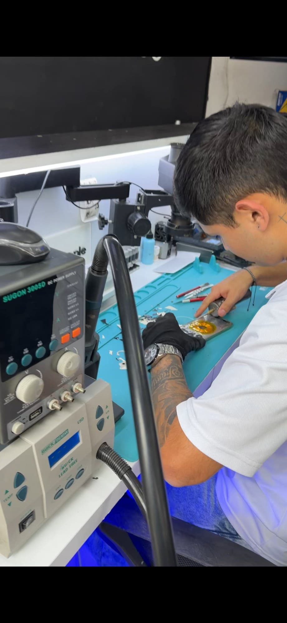 Técnico de MacApple Service realizando limpieza de placa lógica de iPhone con daño por líquido en taller especializado de Fusagasugá